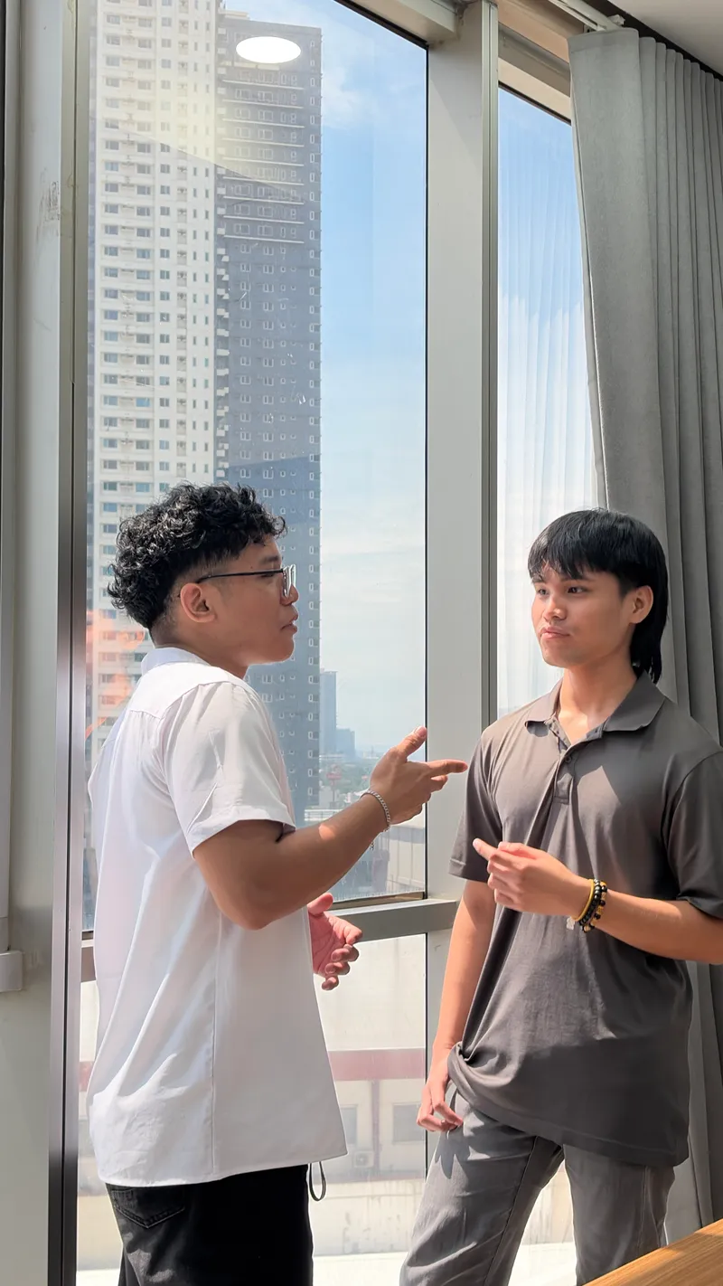 窓際で会話するWarrenとRoland